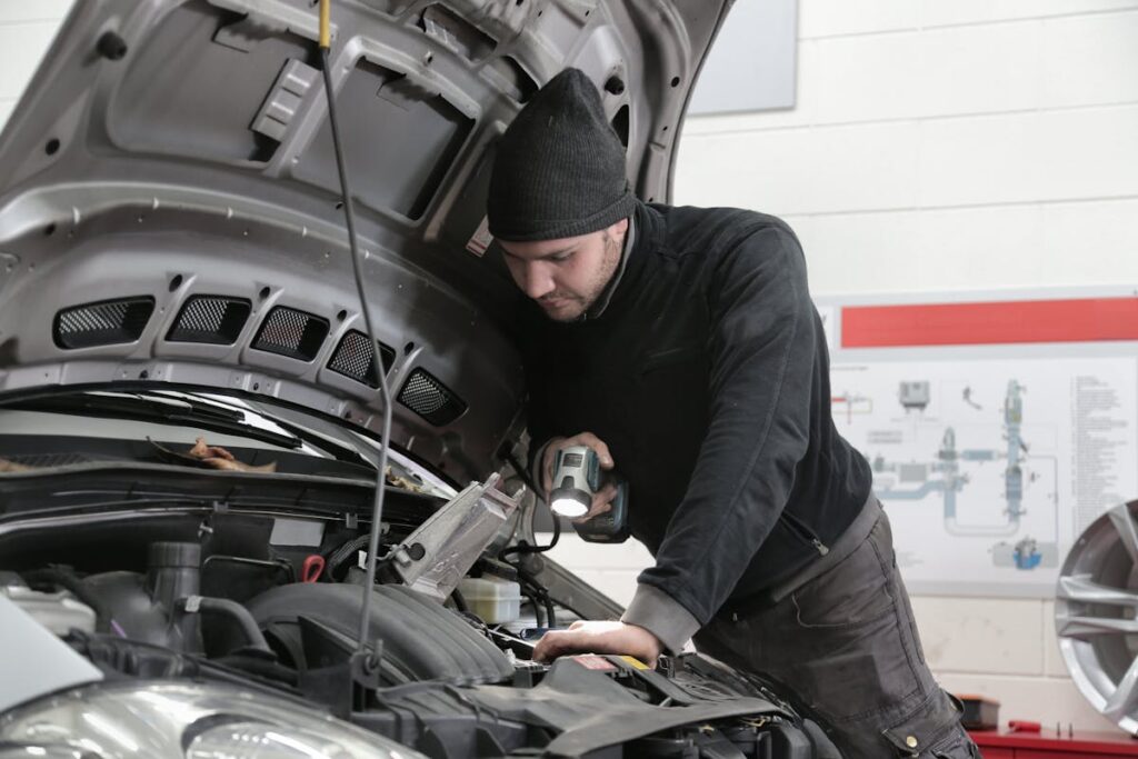 KFZ Gutachten - Mechaniker inspiziert Fahrzeug in Werkstatt